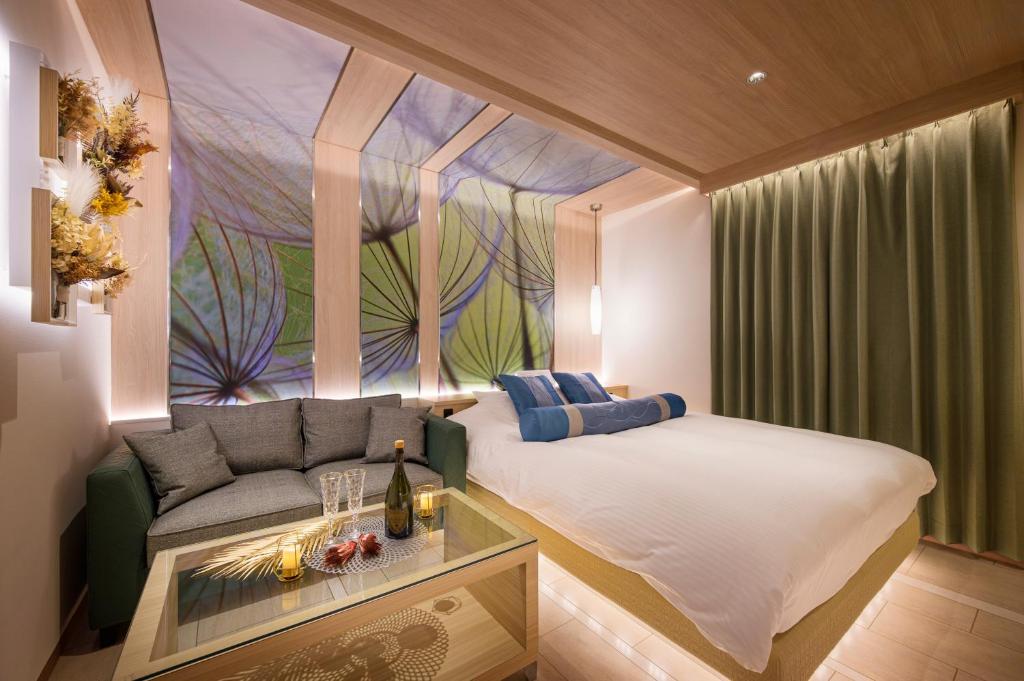 une chambre avec un lit, un canapé et une fenêtre dans l'établissement ホテルLuce Regaloｰルーチェレガーロ, à Rifu 10 autres photos