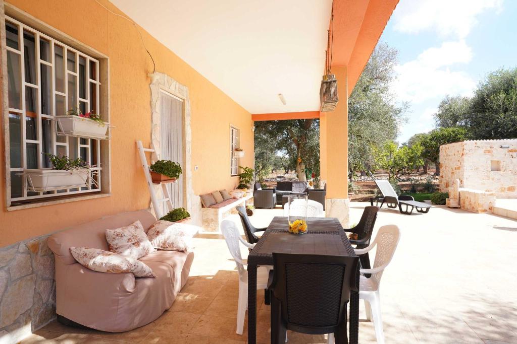 un patio avec un canapé, une table et des chaises dans l'établissement All'ombra degli Ulivi by BarbarHouse, à Latiano