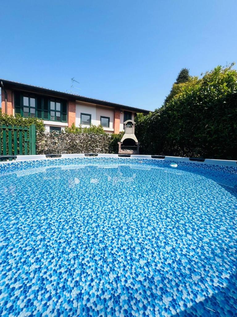 une grande piscine bleue devant une maison dans l'établissement Villetta faustina, à Albairate