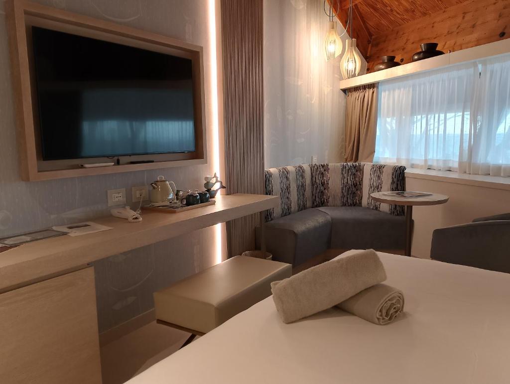 Cette chambre dispose d'une table, d'une télévision et d'une chaise. dans l'établissement La Bussola Beach Hotel, à Punta Ala