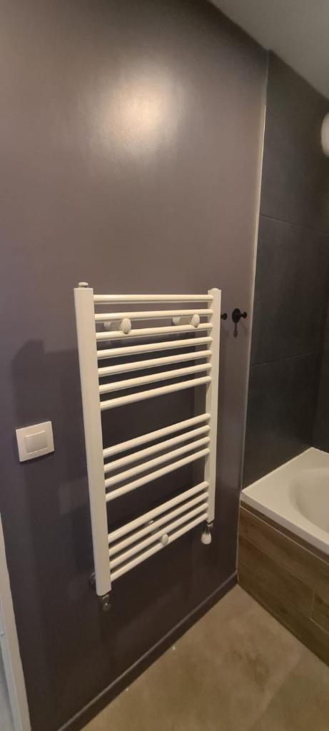 une salle de bain avec un radiateur blanc au mur dans l'établissement Crests Lodge - Plagne -Villages 2100m - Classé 4 étoiles, à La Plagne Tarentaise