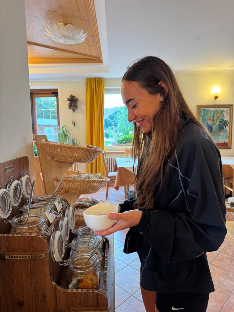 une femme tient un bol dans une cuisine dans l'établissement Hotel Al Lago, à Lavarone