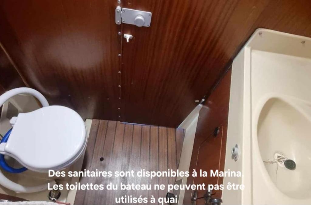 une salle de bain avec toilettes, lavabo et baignoire dans l'établissement Nuit romantique sur un bateau à Deauville, à Deauville