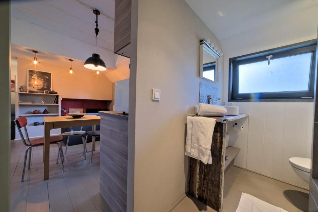 - une petite cuisine et une salle à manger avec une table dans une pièce dans l'établissement Péniche MaPensée, à Metz