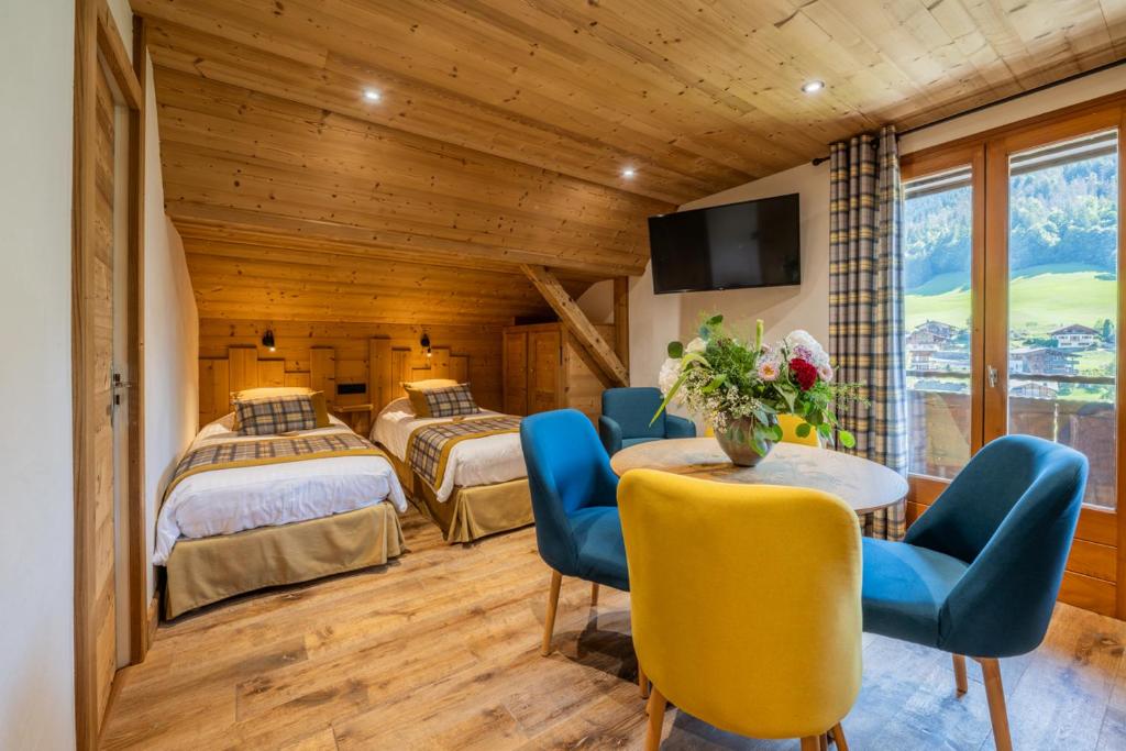 une chambre avec deux lits et une table et des chaises dans l'établissement Hôtel Le Sporting, à Morzine 92 autres photos