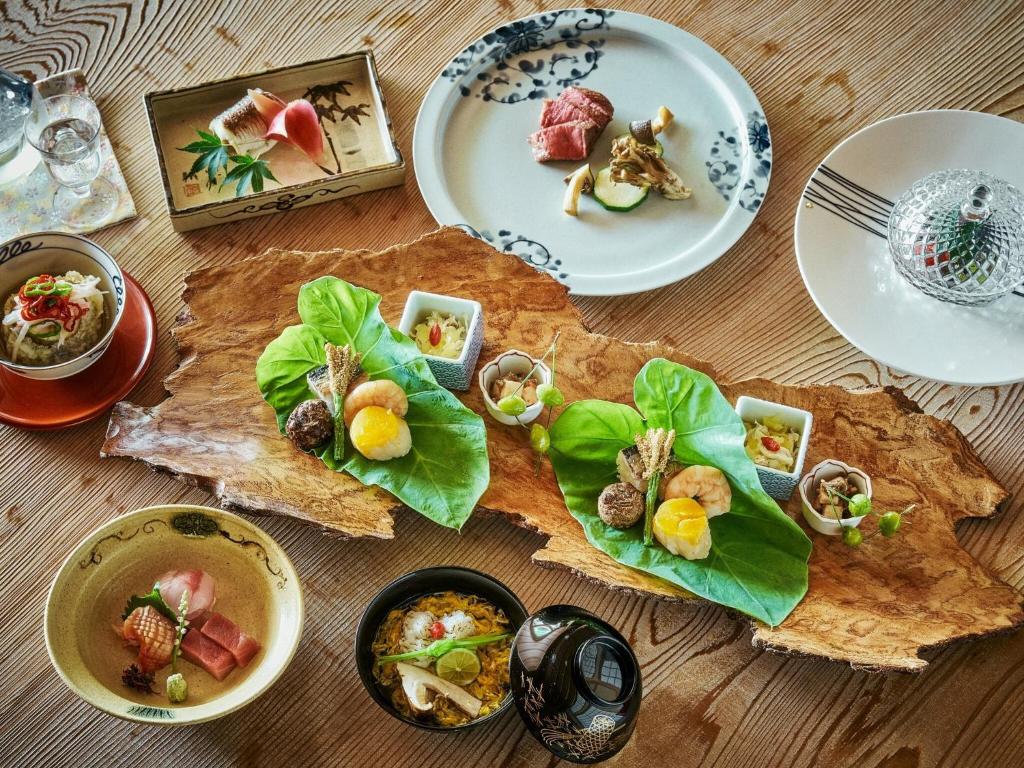 une table avec des assiettes de nourriture dessus dans l'établissement Hakone Retreat villa 1/f, à Hakone