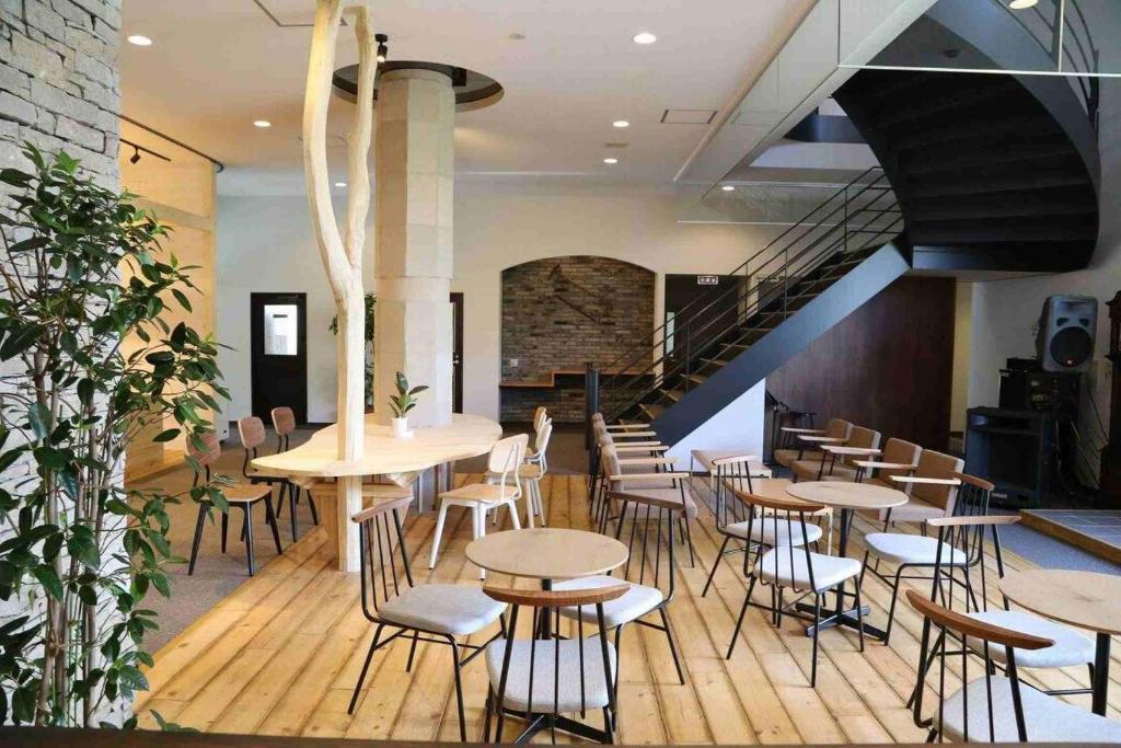 un restaurant avec des tables et des chaises et un escalier dans l'établissement Hotel Yume-no-yu, à Omachi