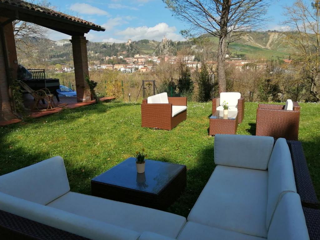 - une cour avec des chaises, un canapé et une table dans l'établissement Villa delle rose Brisighella, à Brisighella