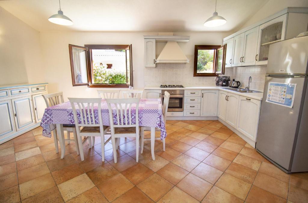 une cuisine avec une table, des chaises et un réfrigérateur dans l'établissement Villa Gallura Dream, à Budoni 14 autres photos
