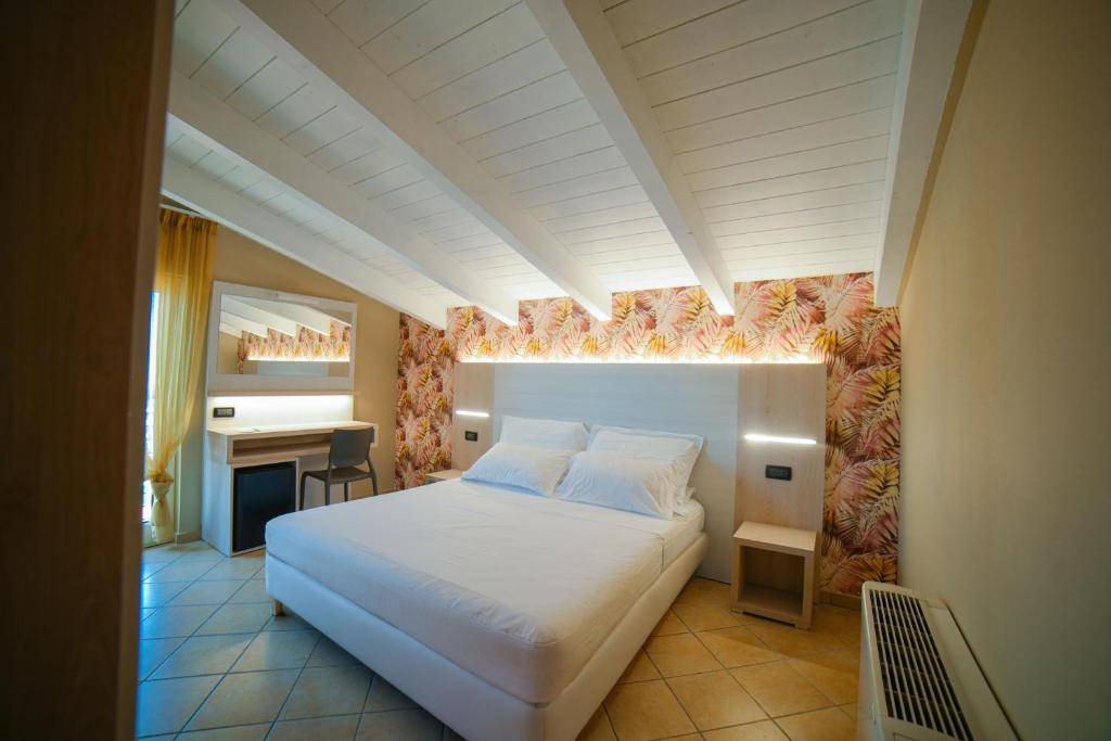 une chambre avec un lit blanc et un bureau dans l'établissement Hotel Prestige, à Montesilvano