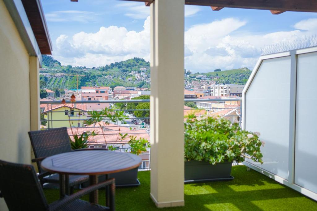un balcon avec une table et une vue sur une ville dans l'établissement Hotel Prestige, à Montesilvano
