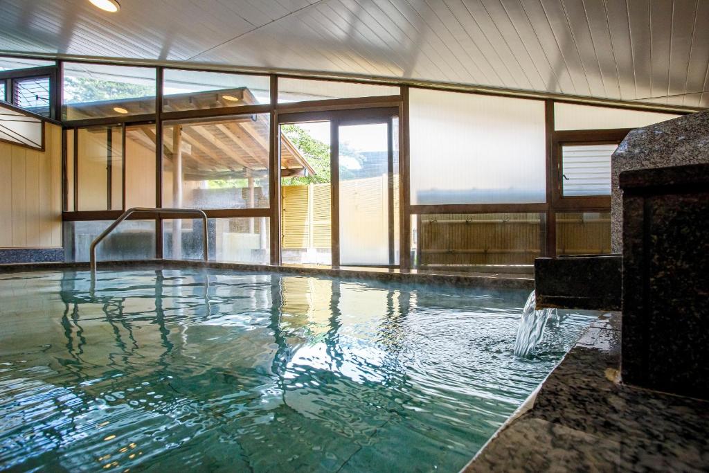 une piscine dans un immeuble avec une grande fenêtre dans l'établissement Hakone Kowakien Mikawaya Ryokan, à Hakone