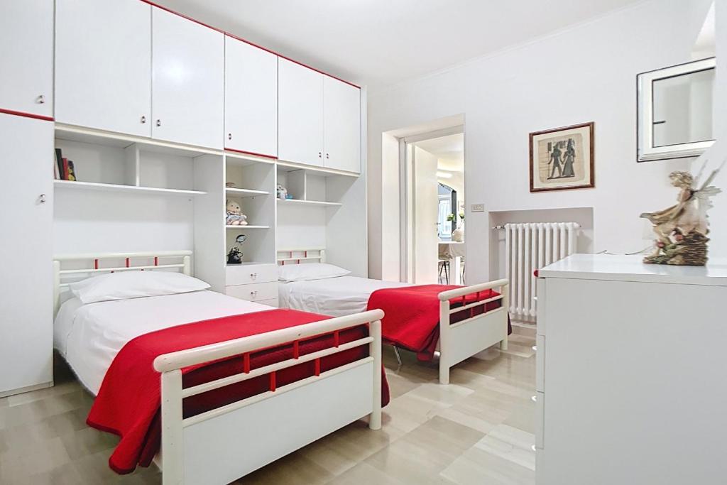 - 2 lits dans une chambre avec des armoires blanches dans l'établissement Villa La Tesa, à Monte SantʼAngelo