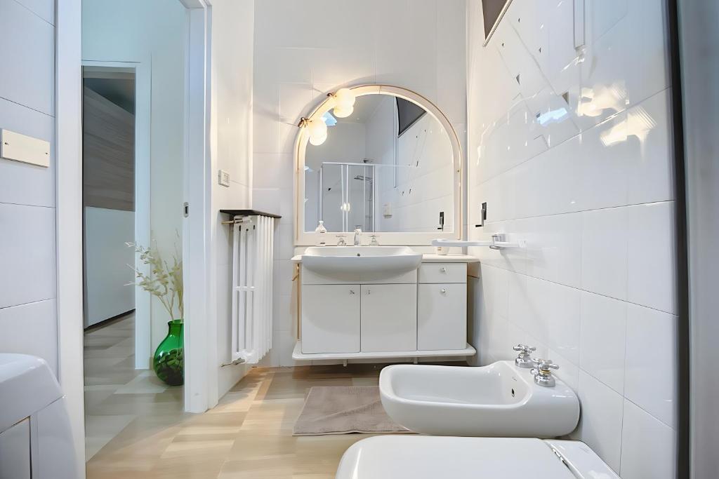 une salle de bain blanche avec un lavabo et un miroir dans l'établissement Villa La Tesa, à Monte SantʼAngelo