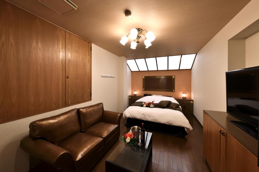 une chambre avec un lit, un canapé et une télévision dans l'établissement HOTEL MYTH-Y ホテル マイス ワイ adult only, à Kotohira