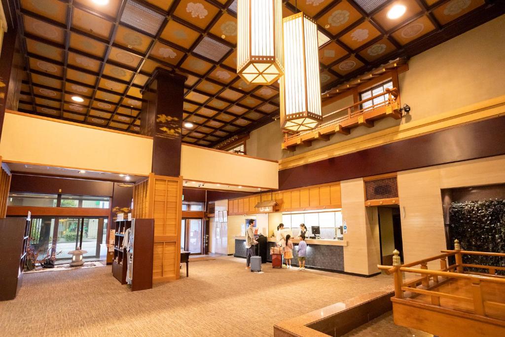 un grand hall avec des personnes debout dans un bâtiment dans l'établissement Ooedo Onsen Monogatari Yamashiro Saichoraku, à Kaga