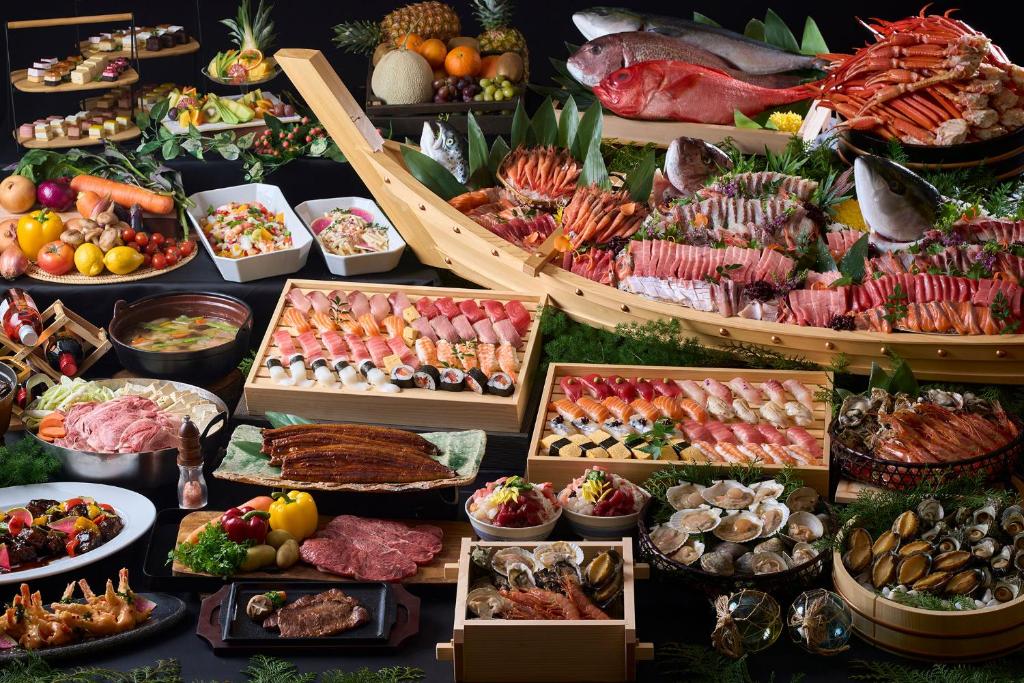 un buffet de différents types de nourriture sur une table dans l'établissement Ooedo Onsen Monogatari Awazu Grand Hotel, à Komatsu