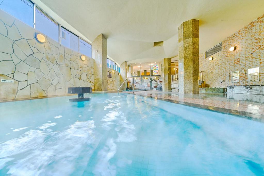 une piscine à l'eau bleue dans un immeuble dans l'établissement Ooedo Onsen Monogatari Gero Bekkan, à Gero