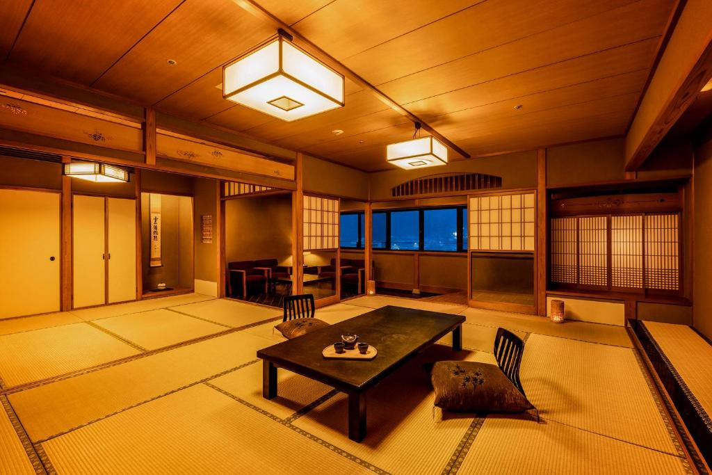 une pièce avec une table et des chaises dans une pièce dans l'établissement Ooedo Onsen Monogatari Miyoshiya, à Yumura