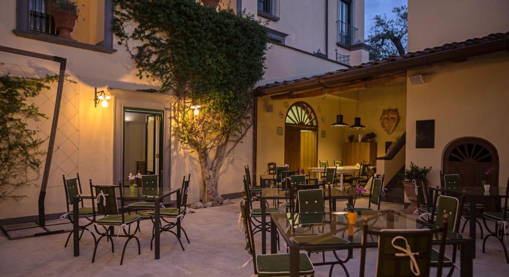 - un groupe de tables et de chaises dans une cour dans l'établissement Relais Regina Giovanna, à Sorrente