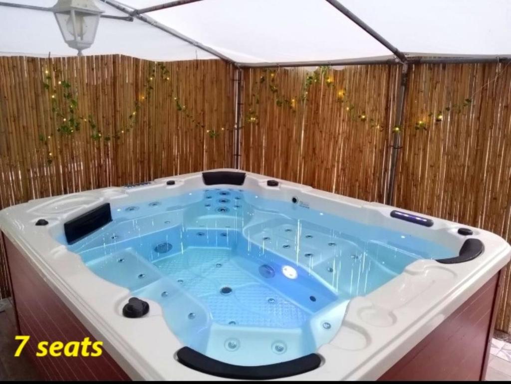 une baignoire jacuzzi dans une pièce avec clôture dans l'établissement VILLA STRAVANATA - Large Pool, Car and Large Whirlpool Jacuzzi, à San Gregorio