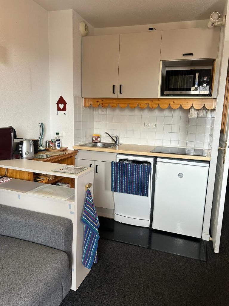 une petite cuisine avec des armoires blanches et un évier dans l'établissement Studio 4 à 5 personnes - Les balcons de Sirius RISOUL, à Risoul 9 autres photos