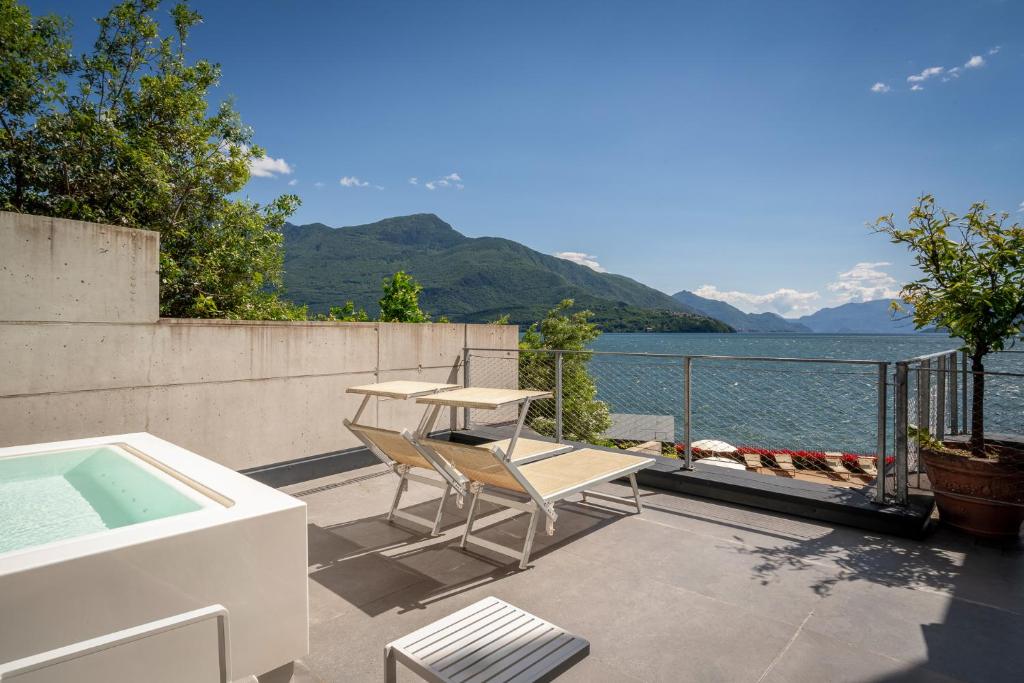 une terrasse avec une table et une chaise ainsi qu'une piscine dans l'établissement Hotel Regina, à Gravedona