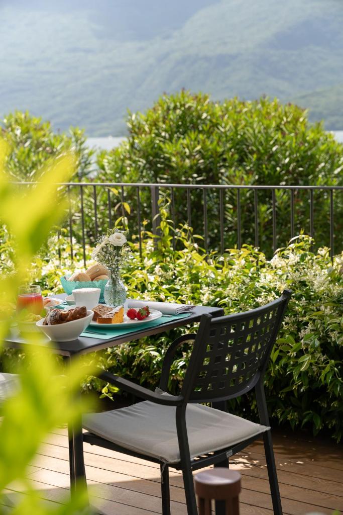 une table avec une assiette de nourriture assise sur une terrasse dans l'établissement Hotel Regina, à Gravedona