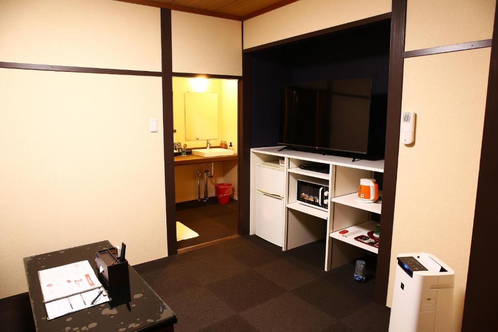 une chambre avec une télévision et une chambre avec une autre chambre dans l'établissement ホテルサルビア, à Tendō