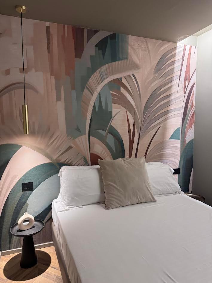 une chambre avec un lit avec un tableau sur le mur dans l'établissement Rock Crystal Boutique Hotel, à Gabicce Mare