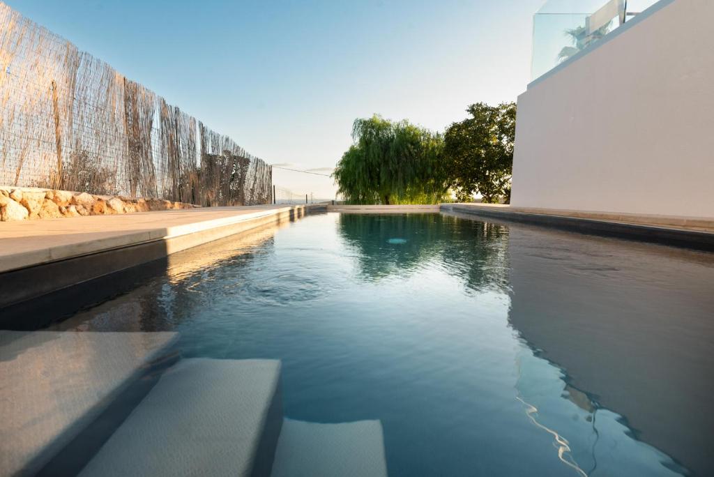 un bassin d'eau à côté d'un mur dans l'établissement Villa Li Munti con piscina, à Marina di Leuca