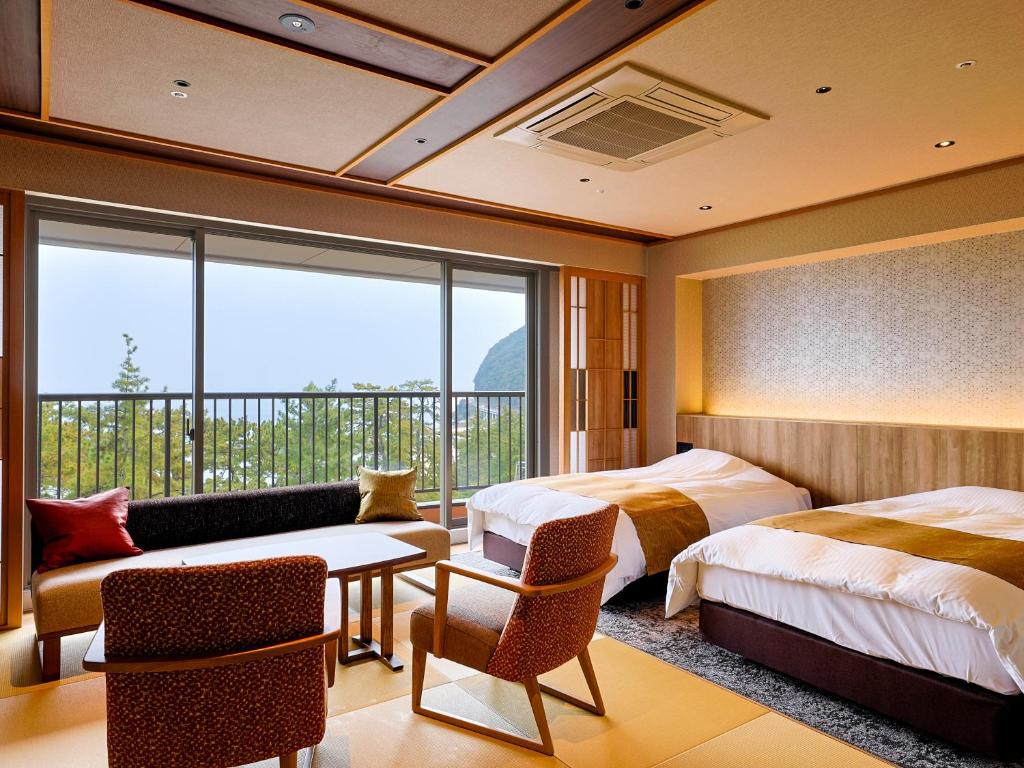 une chambre d'hôtel avec deux lits et un balcon dans l'établissement Yumekaiyu Awajishima, à Sumoto