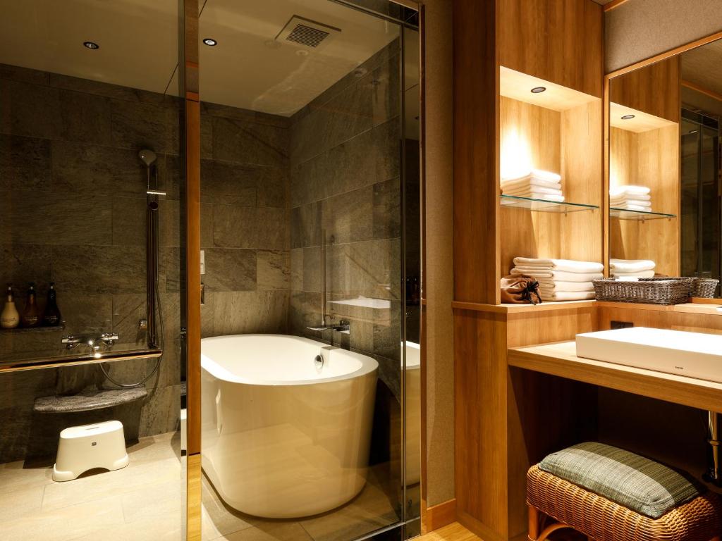 une salle de bain avec une baignoire, un lavabo et une douche dans l'établissement Yumekaiyu Awajishima, à Sumoto