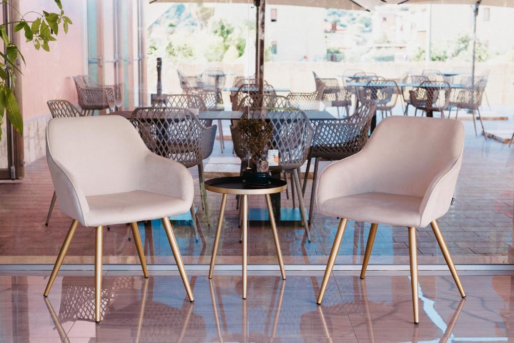 - deux chaises blanches et une table dans une pièce dans l'établissement Hotel Chiaro di Luna, à Marina di Ascea 22 autres photos