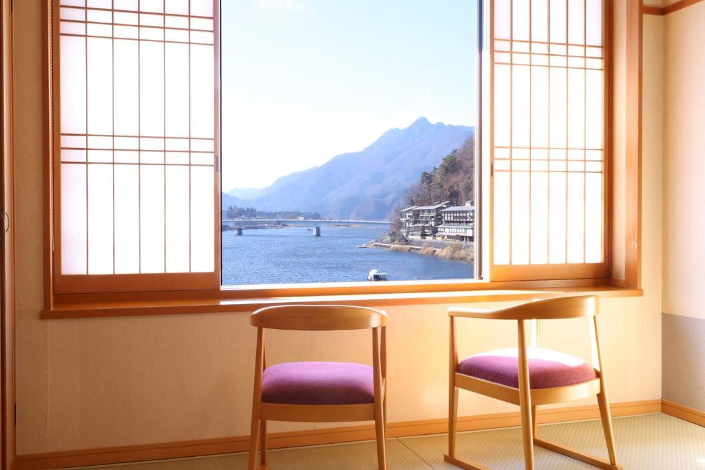 une table et deux chaises devant une fenêtre dans l'établissement Hotel Asafuji, à Fujikawaguchiko 81 autres photos
