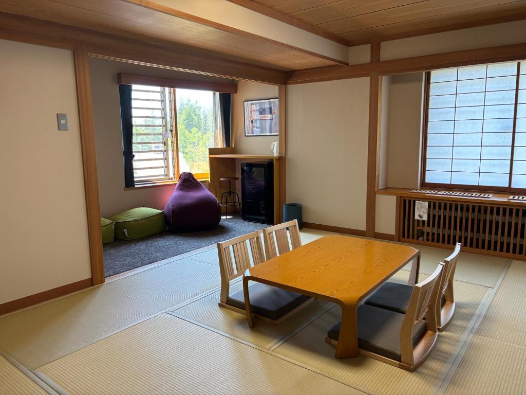 un salon avec une table et des chaises en bois dans l'établissement Club Wyndham Shirakabaso Shigakogen, à Yamanouchi
