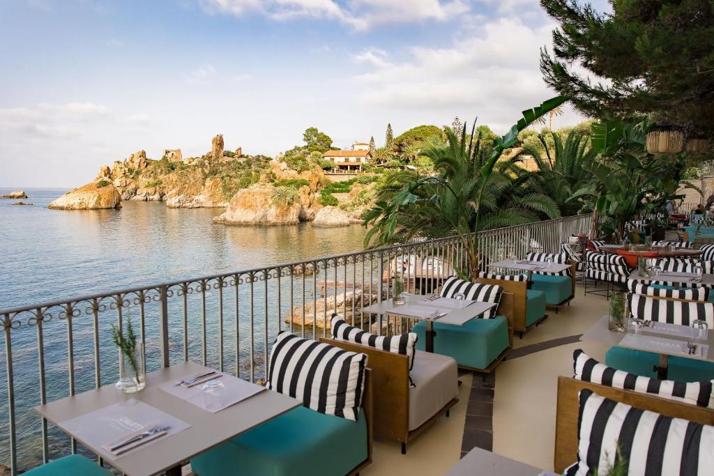 un restaurant avec des tables et des chaises au bord de l'eau dans l'établissement Le Calette N.5, à Cefalù