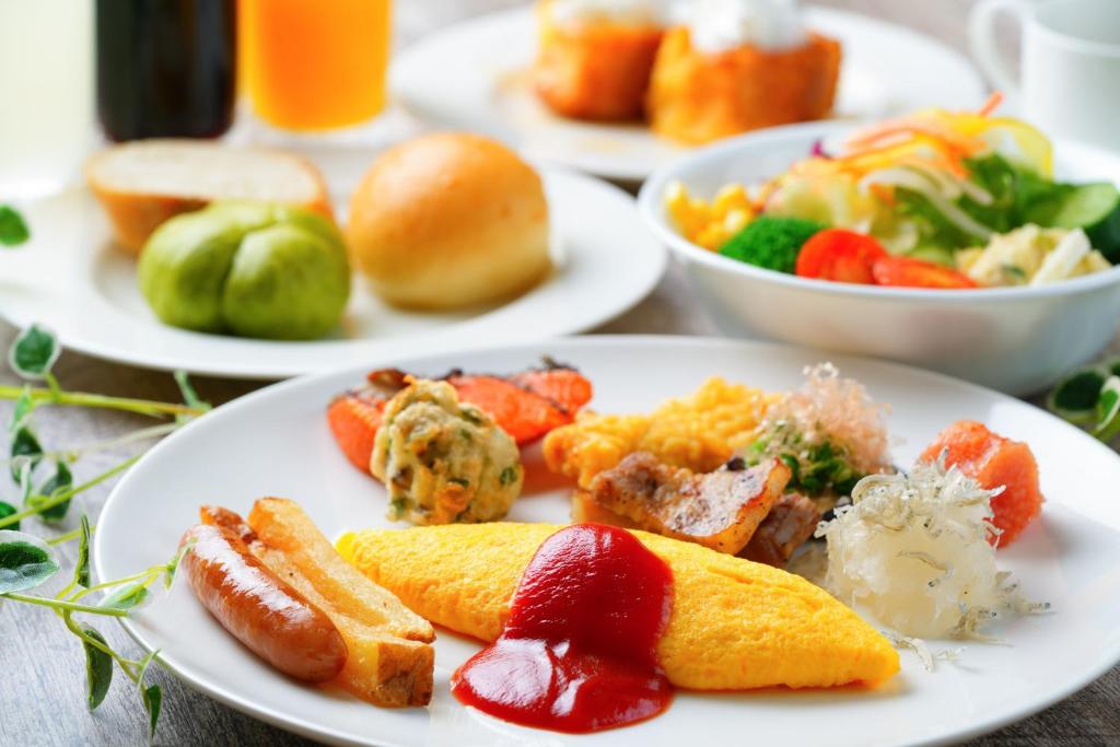 une table avec des assiettes de petit-déjeuner dessus dans l'établissement Shiragiku, à Beppu