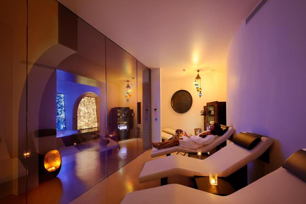 un salon avec une femme assise sur un canapé dans l'établissement Le Calette Bay, à Cefalù