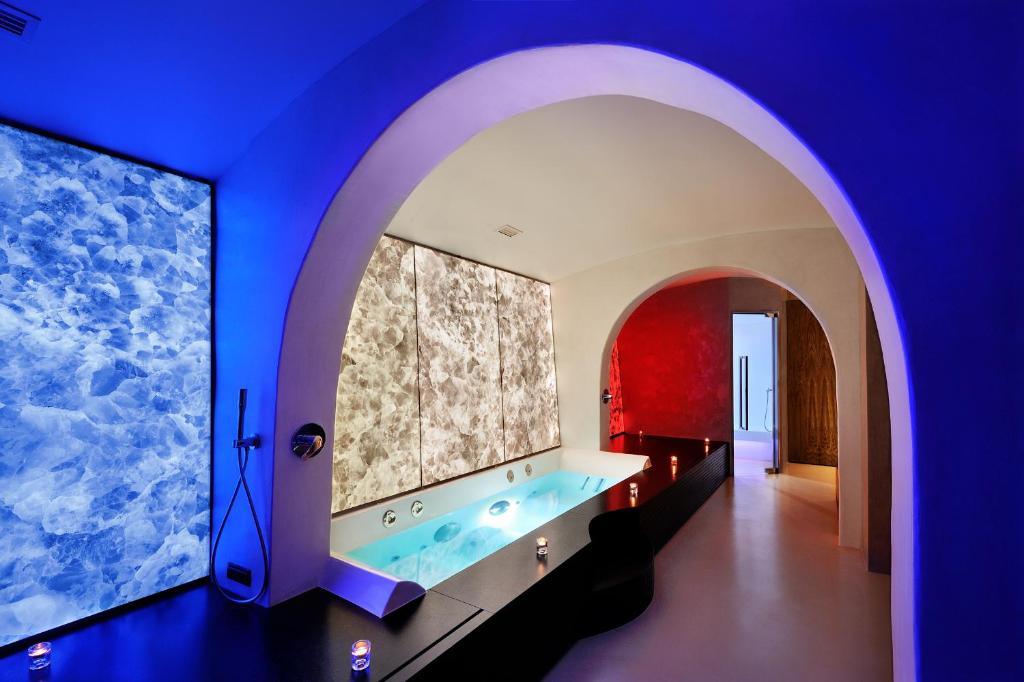 une salle de bain avec une grande baignoire dans une pièce bleue dans l'établissement Le Calette Bay, à Cefalù