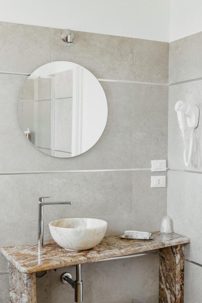 une salle de bain avec un lavabo et un miroir dans l'établissement Hotel Chiaro di Luna, à Marina di Ascea