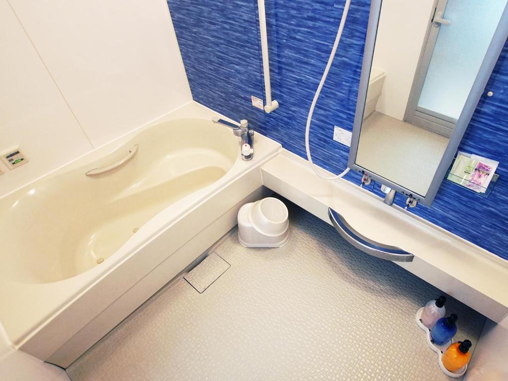 La salle de bains est pourvue d'une baignoire, de toilettes et d'un miroir. dans l'établissement Mariage Hotel - Adults Only -, à Tsukuba