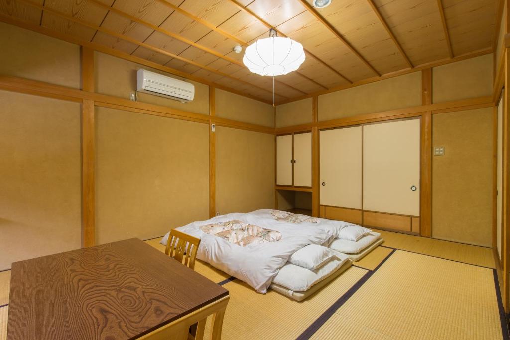une pièce avec un lit et une table dedans dans l'établissement Kazeya, à Takayama