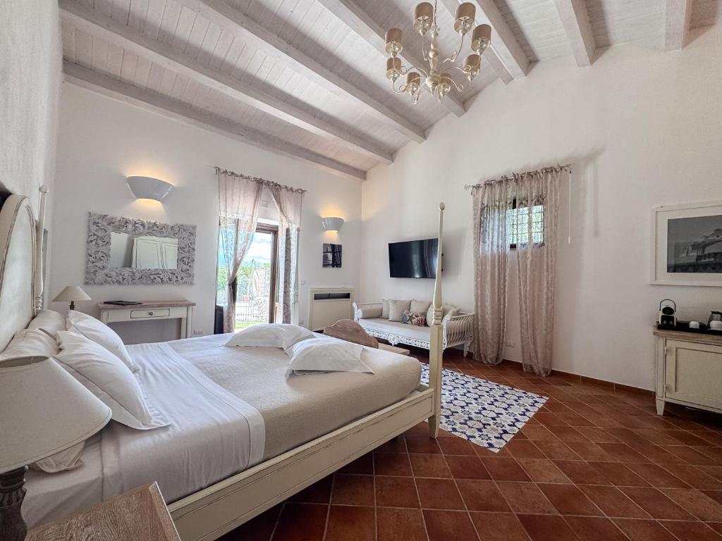 une chambre avec un grand lit et un lustre dans l'établissement Hotel La Corte Del Sole, à Noto