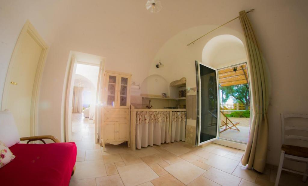 un salon avec une porte ouverte sur une cuisine dans l'établissement Panoramic trulli with swimming pool in Monopoli, à Monopoli