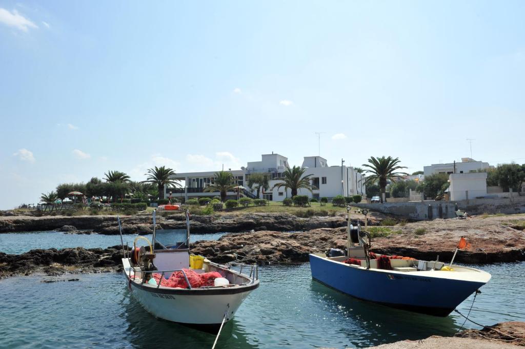 deux bateaux sont amarrés dans l'eau dans l'établissement Hotel Il Timone, à Specchiolla