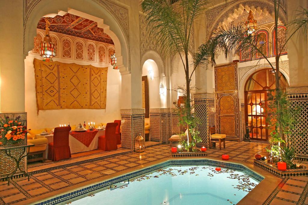 une grande chambre avec une piscine dans un bâtiment dans l'établissement Riad & Spa Esprit Du Maroc, à Marrakech