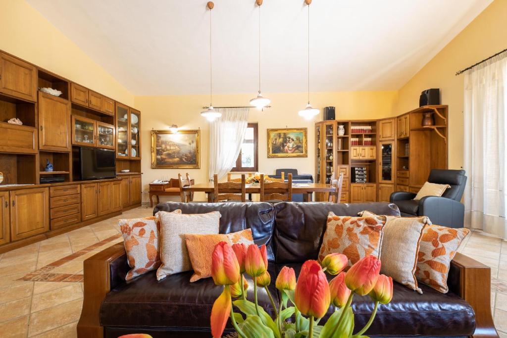 un salon avec un canapé en cuir avec des fleurs dans l'établissement Villa Esmeralda, à Taviano