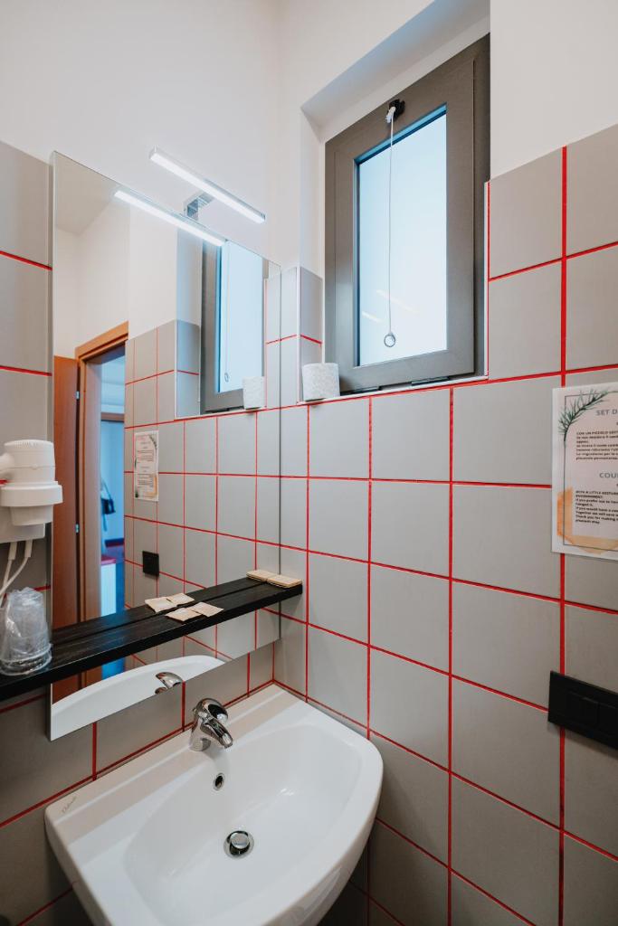 une salle de bain avec un lavabo et un miroir dans l'établissement Eden Hotel, à San Salvo