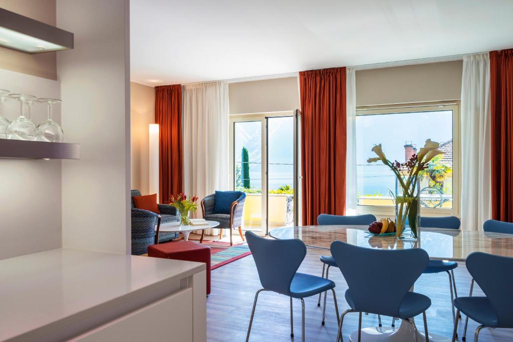 un salon avec une table et des chaises dans l'établissement Parco San Marco Lifestyle Beach Resort, à Porlezza